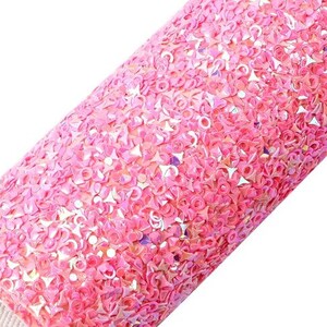 May include: Pink iridescent glitter fabric with a textured surface. The fabric is rolled up and the edge is visible.