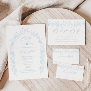 May include: A blue and white baby shower invitation with floral designs and the text "Baby in Bloom" and "Haley Lud". The invitation includes the date, time, and location of the shower. There are also two cards for a nappy raffle and a book request for the baby.