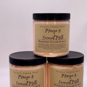 May include: Three jars of mango and coconut milk whipped sugar scrub. The jars are labeled "Tickle Creek Soap" and have a peach colored scrub inside. Each jar is 8 oz.