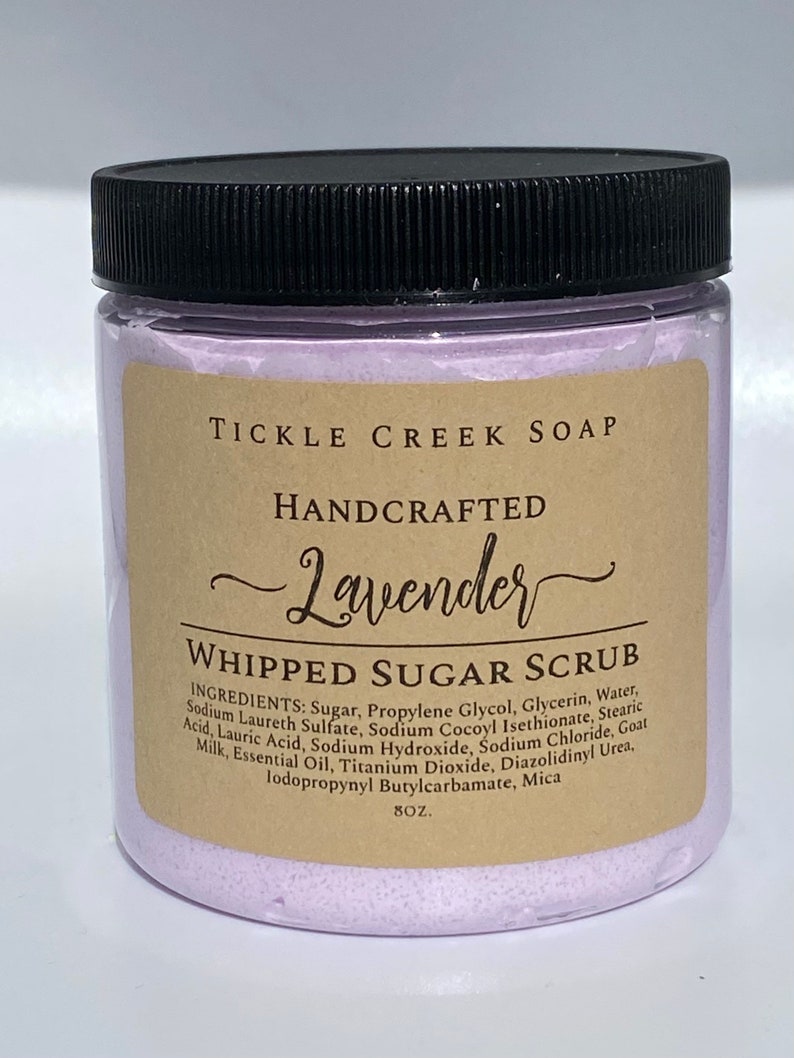 May include: A purple jar of lavender-scented whipped sugar scrub with a black lid. The jar is labelled "Tickle Creek Soap" and "Handcrafted Lavender Whipped Sugar Scrub". The ingredients are listed on the label.