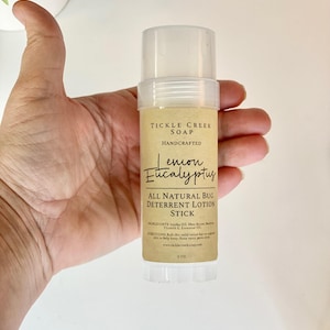 May include: A brown and white label on a clear plastic tube reads "Tickle Creek Soap Handcrafted Lemon Eucalyptus All Natural Bug Deterrent Lotion Stick 2 oz".