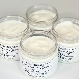 May include: Four glass jars of face lotion with white labels. The labels have black text that reads "Tickle Creek Soap Lavender + Green Tea Face Lotion Net Wt. 2oz/56.7g".