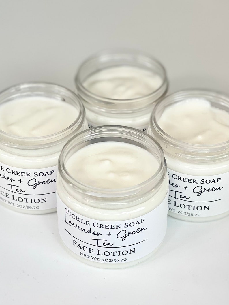 May include: Four glass jars of face lotion with white labels. The labels have black text that reads "Tickle Creek Soap Lavender + Green Tea Face Lotion Net Wt. 2oz/56.7g".