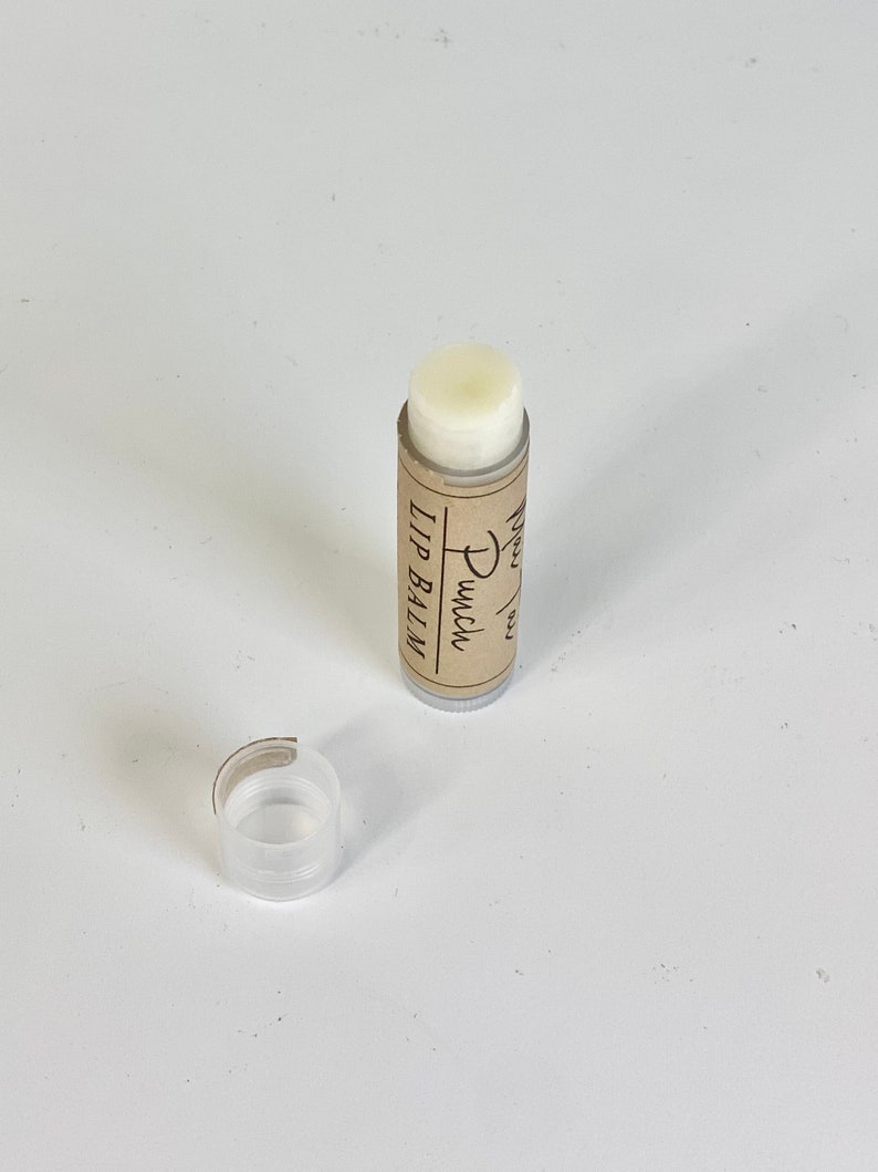 May include: A brown tube of lip balm with the text "Lip Balm" and "Punch" written on it. The lip balm is white and the tube is partially open.