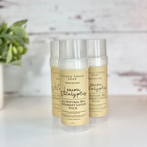 May include: Three brown and white labeled tubes of lemon eucalyptus bug deterrent lotion stick. The label reads "Tickle Creek Soap Handcrafted Lemon Eucalyptus All Natural Bug Deterrent Lotion Stick".
