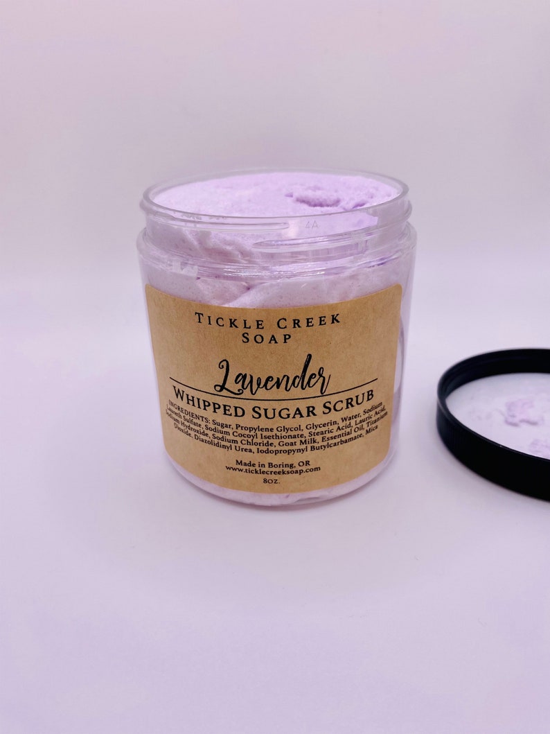 May include: A glass jar of lavender whipped sugar scrub with a brown label that reads "Tickle Creek Soap Lavender Whipped Sugar Scrub". The label lists the ingredients and instructions for use. The jar is 8 oz.