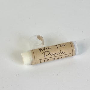 May include: A white lip balm tube with a brown label that reads "Mai Tai Punch Lip Balm".