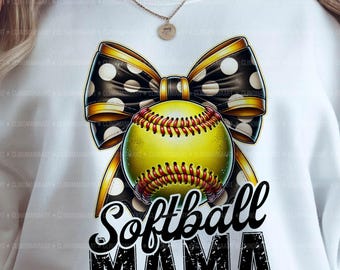 May include: A white sweatshirt with a black and white polka dot bow with a yellow softball in the center. The text "Softball Mama" is written in black with a distressed look.