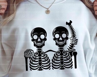 May include: Two black skeleton figures with smiling skulls, one with an arm raised in the air, hugging each other. The skeletons are outlined in black against a white background.