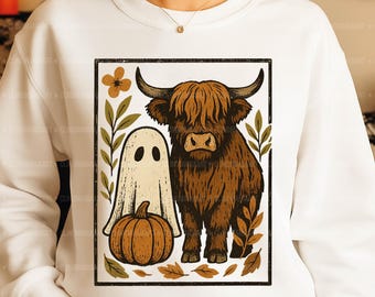 May include: White sweatshirt featuring a Halloween-themed graphic. The design includes a brown Highland cow, a ghost, and a pumpkin, all framed within a black border. The words "Digital Download | PNG" are at the bottom.