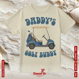 May include: Cream-colored t-shirt featuring a blue golf cart graphic with the text "DADDY'S GOLF BUDDY" in a retro font. The shirt also has the text "DIGITAL DOWNLOAD" and "HIGH-QUALITY 300 DPI PNG".