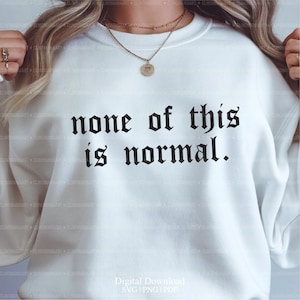 以下が含まれることがあります： 黒いゴシック体で「none of this is normal」と書かれた白いスウェットシャツ。画像には「Digital Download SVG | PNG | PDF」というテキストも含まれています。