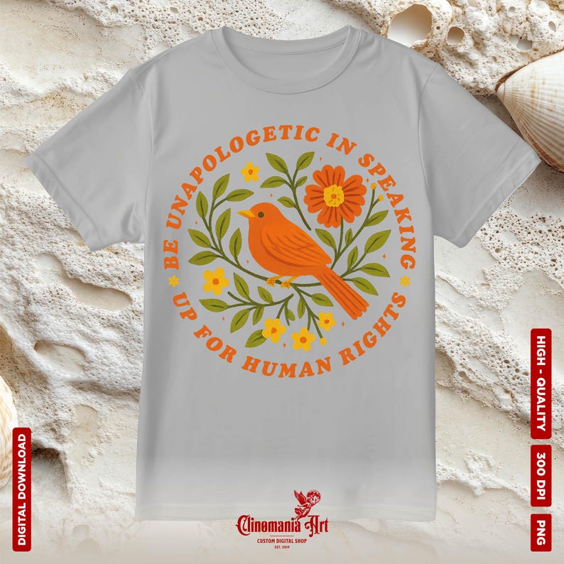 May include: A light gray t-shirt featuring a circular design with an orange bird, flowers, and the text "BE UNAPOLOGETIC IN SPEAKING UP FOR HUMAN RIGHTS." The design is surrounded by green leaves and yellow flowers. The shirt also has the text "DIGITAL DOWNLOAD" and "HIGH-QUALITY 300 DPI PNG."