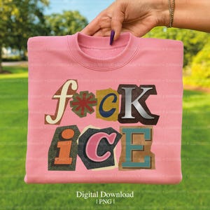May include: Pink sweatshirt with the words "f*ck ice" in a collage style. The letters are in various colors and textures, including brown, blue, and pink. The sweatshirt is folded and held by a hand.