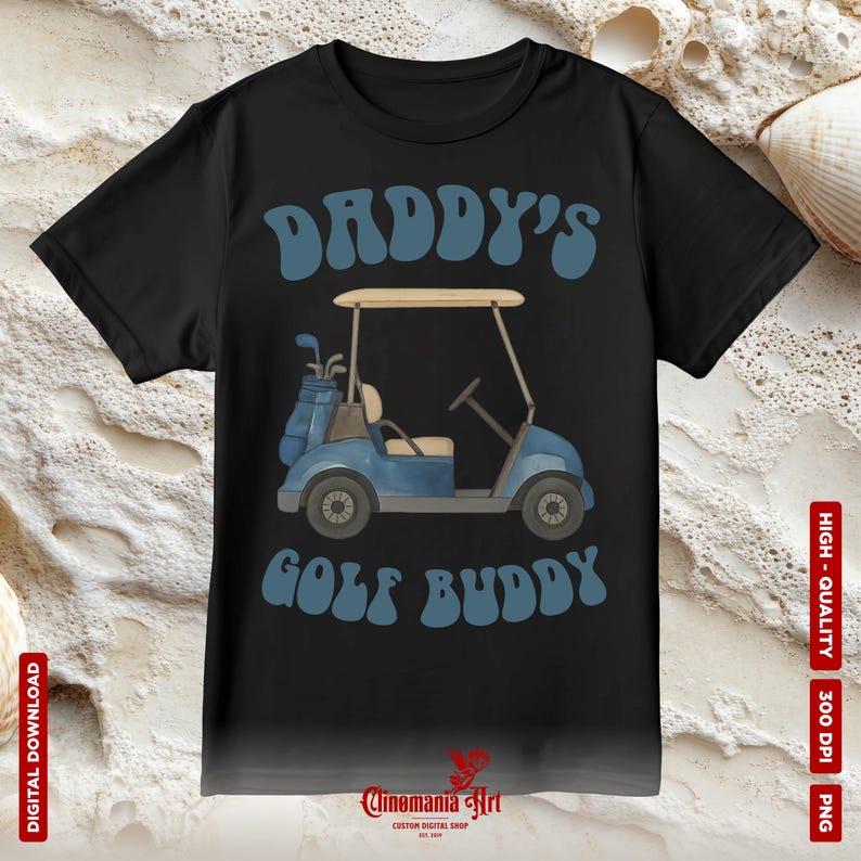 May include: Black t-shirt with the words "DADDY'S GOLF BUDDY" in blue, featuring a blue golf cart graphic. The shirt also has a golf bag with clubs. The Cinemania Art logo is at the bottom.