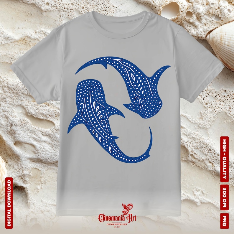 May include: A grey t-shirt featuring a blue graphic of two whale sharks swimming in a circle. The whale sharks have white spots and a white outline. The text "Clinomania Art" is printed on the bottom of the shirt.