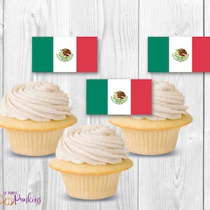 Peut inclure: Trois cupcakes à la vanille avec un glaçage blanc et un dessus de drapeau mexicain sur chacun. Les drapeaux sont vert, blanc et rouge avec les armoiries mexicaines au centre.