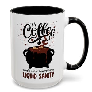 May include: White ceramic coffee mug with a black rim and handle. The mug features a black cauldron with brown coffee beans and steam rising from it. The text "Coffee" is written in black cursive above the cauldron. The text "magic beans brewed into LIQUID SANITY" is written below the cauldron.