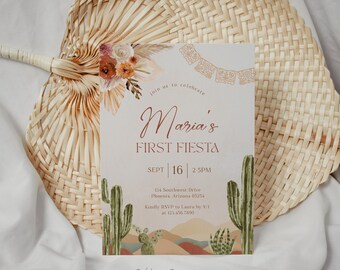 May include: A light pink invitation with a floral design and cactus illustrations. The text reads "Join us to celebrate Maria's First Fiesta Sept 16 2:5PM 134 Southwest Drive Phoenix, Arizona 85254 Kindly RSVP to Laura by 9/1 at 123.456.7890 Dahling Design Co."