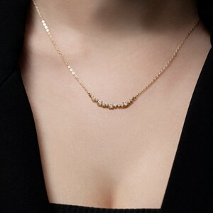 Puede incluir: Un delicado collar de oro con una fila curva de peque&ntilde;os diamantes.