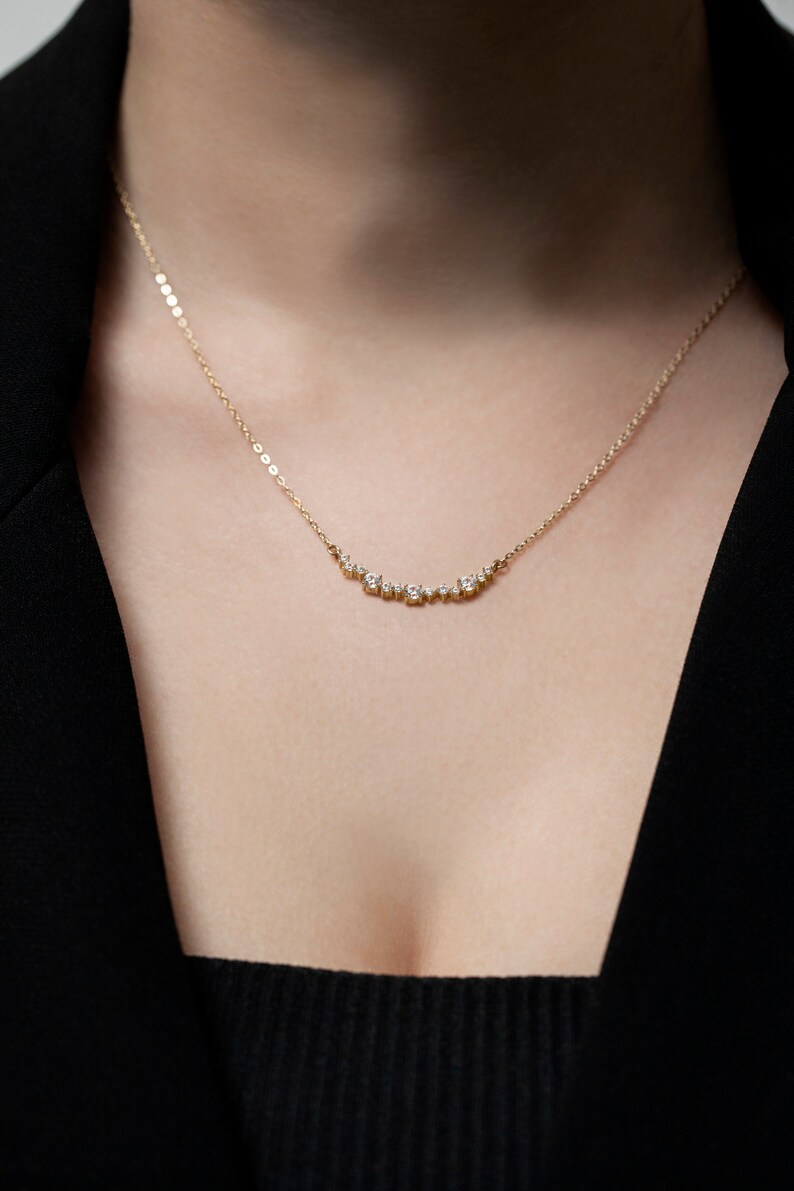 Puede incluir: Un delicado collar de oro con una fila curva de peque&ntilde;os diamantes.