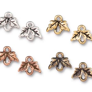 May include: A selection of small, leaf-shaped charms in various metallic finishes. The charms include silver, gold, copper, and bronze tones. Each charm has a loop for attaching to jewellery or other crafts.