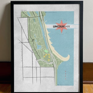 Może przedstawiać: Oprawiony wydruk mapy Lincoln Park w Chicago, Illinois. Mapa przedstawia zielony i beżowy układ parku, niebieską wodę oraz czerwoną grafikę w kształcie rozbłysku gwiazdy ze słowami "Lincoln Park" i "Illinois". Wydruk jest w czarnej ramie.