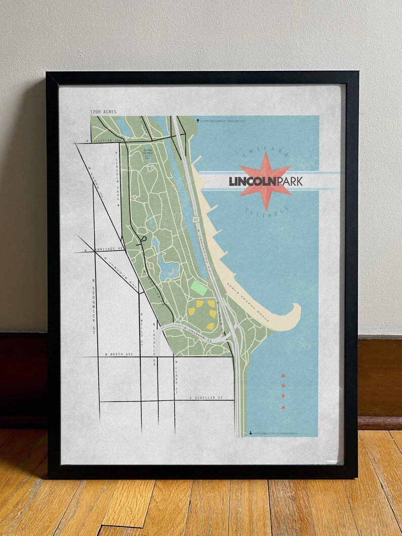 Może przedstawiać: Oprawiony wydruk mapy Lincoln Park w Chicago, Illinois. Mapa przedstawia zielony i beżowy układ parku, niebieską wodę oraz czerwoną grafikę w kształcie rozbłysku gwiazdy ze słowami "Lincoln Park" i "Illinois". Wydruk jest w czarnej ramie.