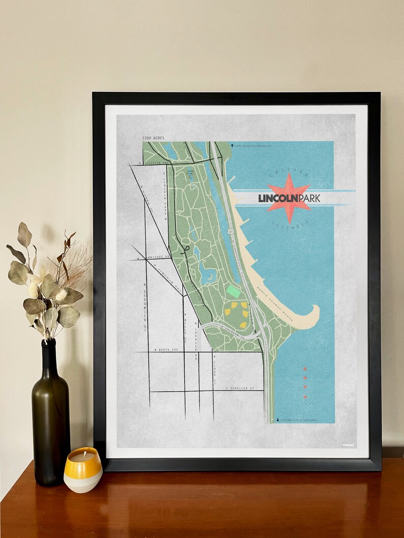 Może przedstawiać: Oprawiony wydruk artystyczny mapy Lincoln Park w Chicago, Illinois. Mapa przedstawia szczeg&oacute;łowy układ parku, z ulicami i zabytkami. Tekst "LINCOLN PARK" jest wyświetlany w stylu retro, z czerwoną gwiazdą. Wydruk jest w czarnej ramie.
