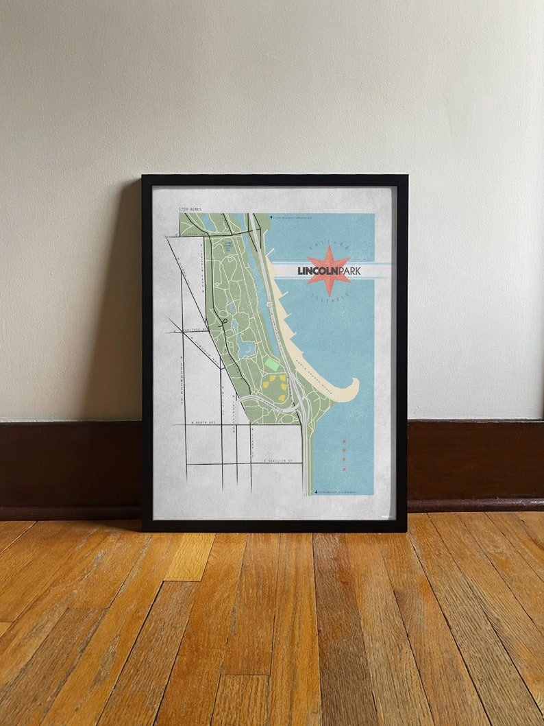 Może przedstawiać: Oprawiony wydruk mapy Lincoln Park, Chicago, z czarną ramą. Mapa przedstawia szczeg&oacute;łową ilustrację parku, ulic i jeziora Michigan. Napis "Lincoln Park" jest w kolorze czerwonym i białym, z motywem rozbłysku.