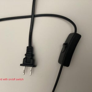 K&ouml;nnte beinhalten: Schwarzes Elektrokabel mit einem Zweipolstecker und einem Ein-/Ausschalter. Der Text im Bild lautet: "6 Fu&szlig; Kabel mit Ein-/Ausschalter." Das Kabel ist etwa 183 cm lang.