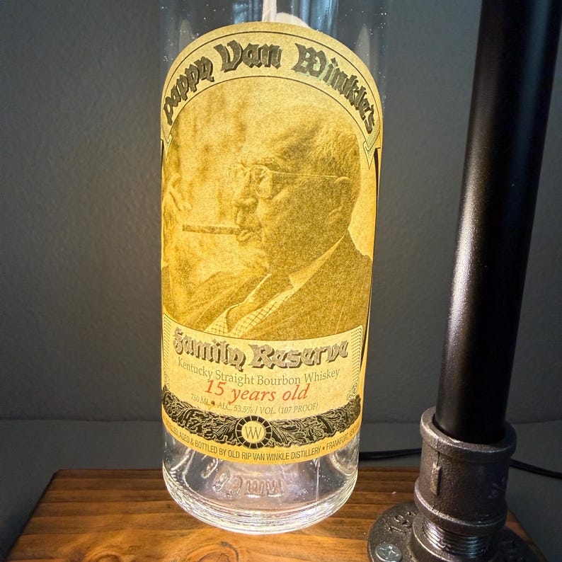 K&ouml;nnte beinhalten: Eine Lampe aus einer recycelten Glasflasche mit dem Etikett "Pappy Van Winkle's Family Reserve" und dem Bild eines Mannes mit Zigarre. Das Etikett weist auch "15 Jahre alt" aus. Die Lampe ist auf einem Holzsockel montiert.