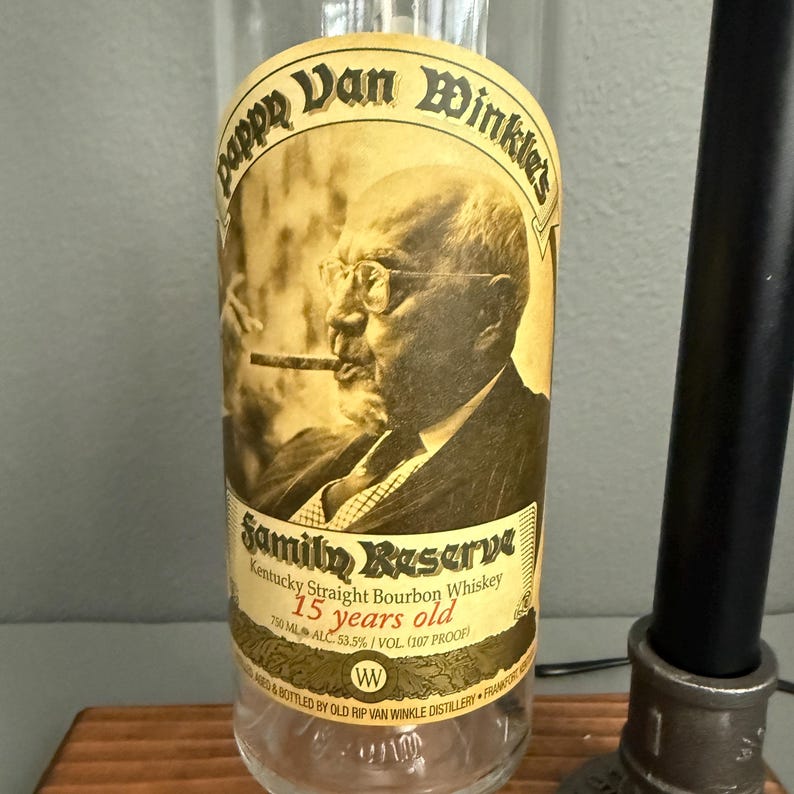 K&ouml;nnte beinhalten: Eine klare Glasflasche Pappy Van Winkle's Family Reserve Kentucky Straight Bourbon Whiskey. Das Etikett zeigt ein Sepia-Portr&auml;t eines Mannes, der eine Zigarre raucht. Der Text lautet "15 Jahre alt" und "750 ml".