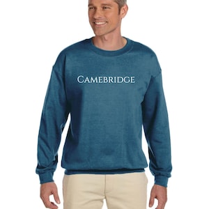 May include: A teal blue sweatshirt with the word "CAMBRIDGE" printed in white on the front.