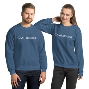 May include: Two blue sweatshirts with the word "CAMBRIDGE" printed in white on the front.