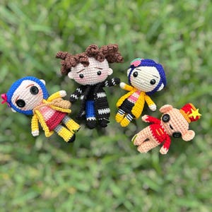 May include: Four handmade crochet dolls, each with unique outfits and features. One doll has blue hair and a yellow coat, another has brown hair and a black coat, and two others have red and yellow outfits. They are arranged on a green grassy surface.
