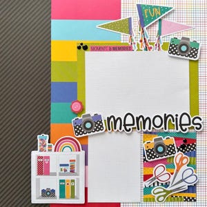 May include: A scrapbook page with a colorful design. It features the word "memories" in black script, decorative cameras, pennant flags, and a shelf with books and a rainbow. The background includes various colors and patterns.