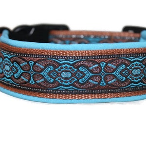 Könnte beinhalten: Ein türkisblaues Hundehalsband mit braunem und schwarzem Muster. Das Halsband hat einen silbernen D-Ring und eine schwarze Schnalle.