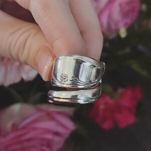K&ouml;nnte beinhalten: Ein silberner L&ouml;ffelring mit einem Blumendesign. Der Ring ist aus einem Vintage-L&ouml;ffel gefertigt und ein einzigartiges Schmuckst&uuml;ck.