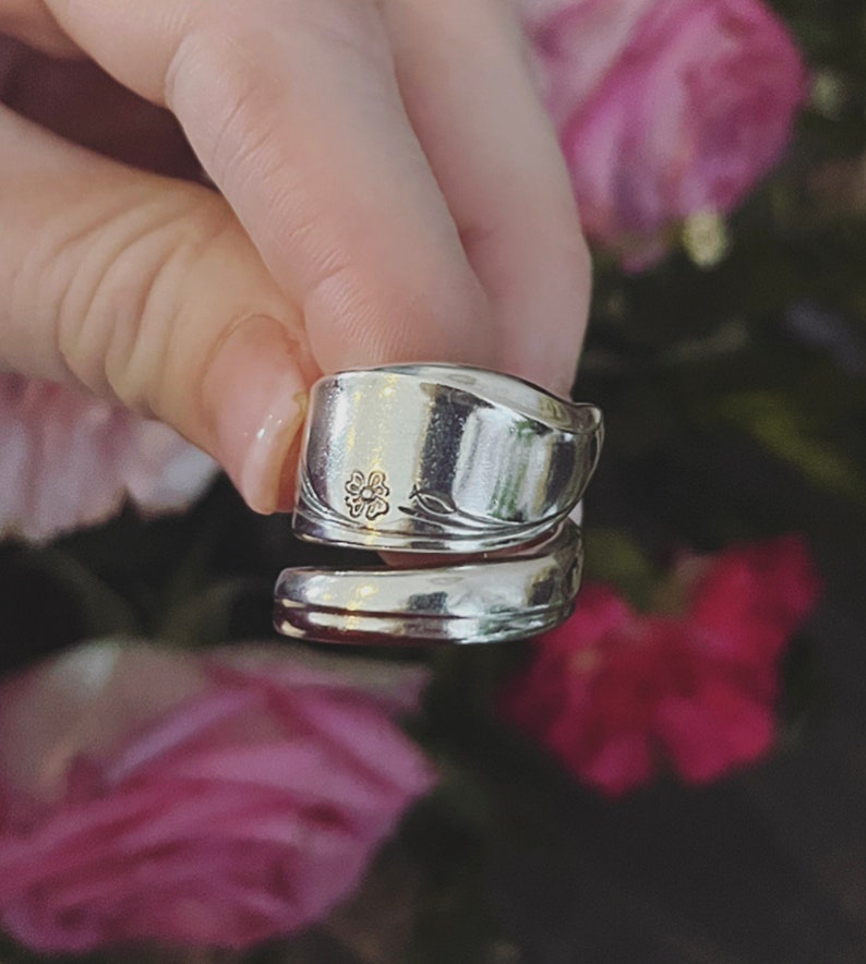 K&ouml;nnte beinhalten: Ein silberner L&ouml;ffelring mit einem Blumendesign. Der Ring ist aus einem Vintage-L&ouml;ffel gefertigt und ein einzigartiges Schmuckst&uuml;ck.