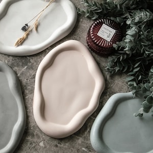 Può includere: Quattro vassoi in ceramica di diversi colori e forme. I vassoi sono realizzati in un materiale liscio e testurizzato e hanno un bordo leggermente rialzato. I vassoi sono perfetti per servire spuntini, antipasti o per esporre oggetti decorativi.