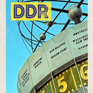 Puede incluir: Un reloj de estilo vintage con un diseño en forma de globo y una pantalla rotativa de números. El reloj presenta un esquema de color amarillo y verde y muestra los números 4, 5 y 6. El reloj también presenta una lista de ciudades de todo el mundo, que incluyen Vancouver, Dawson, San Francisco, Los Ángeles, Edmonton, Denver, Nueva Orleans, Ciudad de México, Montreal, Washington, Nueva York, La Habana y Ciudad de Guatemala.