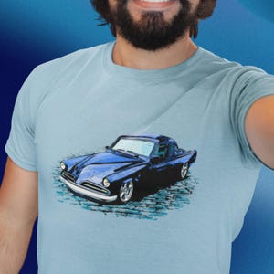 May include: A blue vintage car with a white interior is printed on a light blue t-shirt.