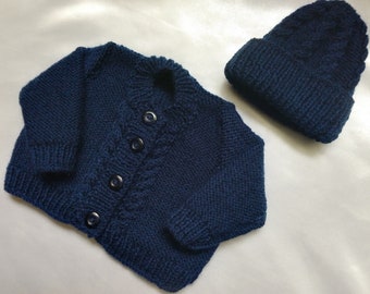 Round neck baby cardigan in navy blue with matching hat.