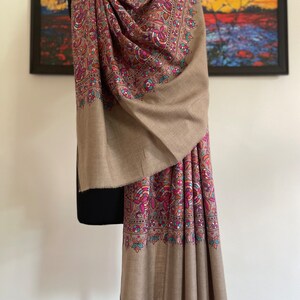 May include: A brown shawl with a colorful floral pattern. The shawl is made of soft, luxurious fabric and is perfect for adding a touch of elegance to any outfit.