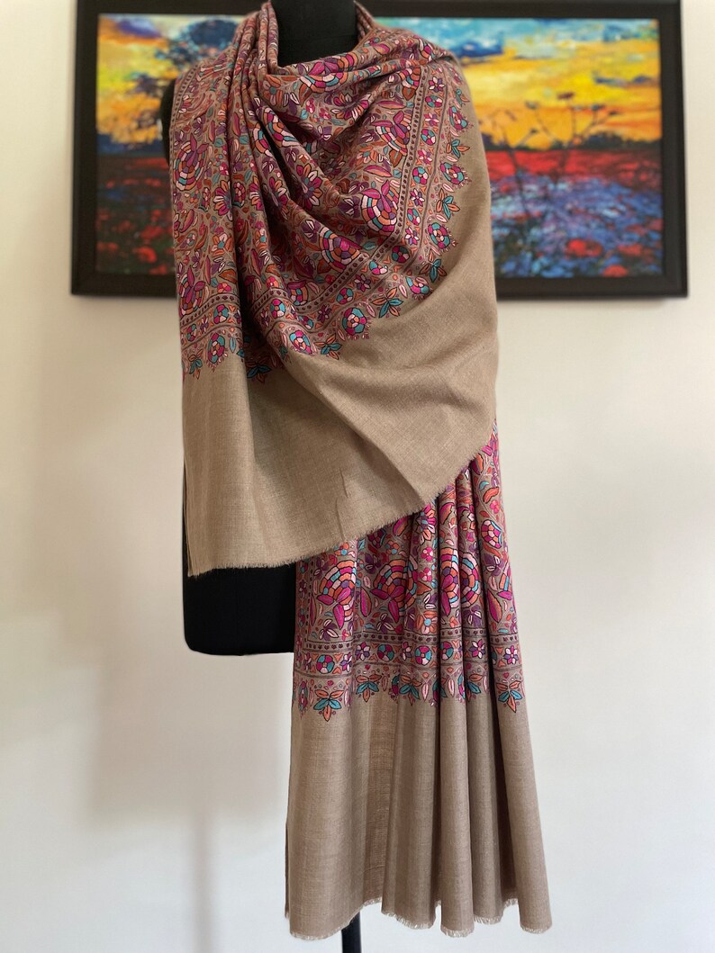 May include: A brown shawl with a colorful floral pattern. The shawl is made of soft, luxurious fabric and is perfect for adding a touch of elegance to any outfit.