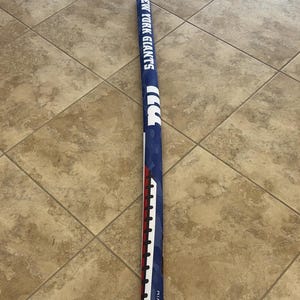 May include: A blue and white swim noodle with the text "NEW YORK GIANTS" printed on it. The noodle has red and white stripes on one side and the text "BT@SWIM" on the bottom.