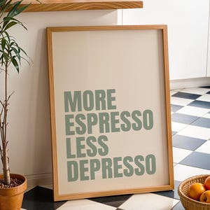 Könnte beinhalten: Ein gerahmter Druck mit dem Text "MORE ESPRESSO LESS DEPRESSO" in grünen Buchstaben. Der Druck lehnt an einer Wand neben einer Topfpflanze und einem Korb mit Orangen. Der Boden hat ein schwarz-weißes Schachbrettmuster.