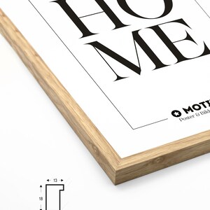 May include: A close-up of the corner of a wood frame with a white poster inside. The poster has the word "HOME" printed in black. The frame is 18 inches by 13 inches.