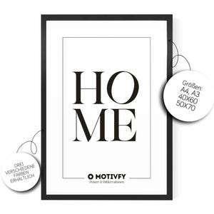 Könnte beinhalten: Ein schwarz gerahmter Druck mit dem Wort "HOME" in großen, fetten, schwarzen Buchstaben auf weißem Hintergrund. Der Druck hat einen schwarzen Rahmen und enthält das "MOTIVFY"-Logo. Größen: A4, A3, 40x60cm und 50x70cm.
